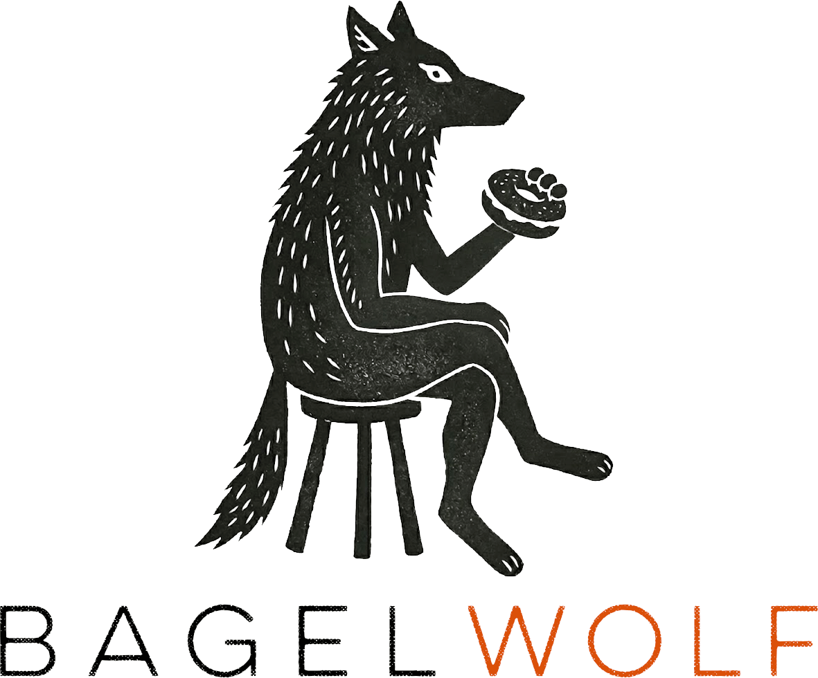 BagelWolf - A wolf sitting on a stool holding a bagel